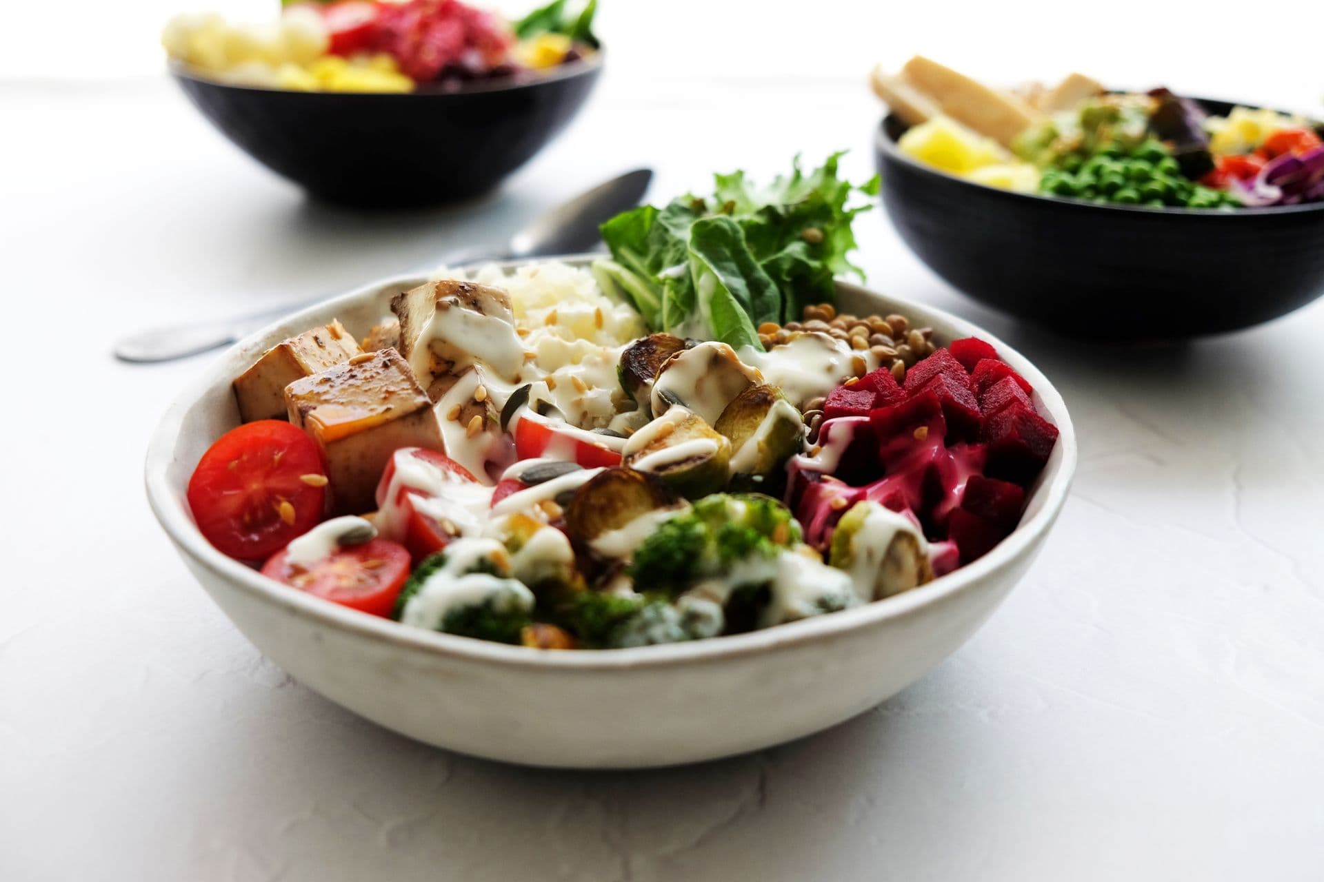 A grain bowl with roasted vegetables, beets and greens